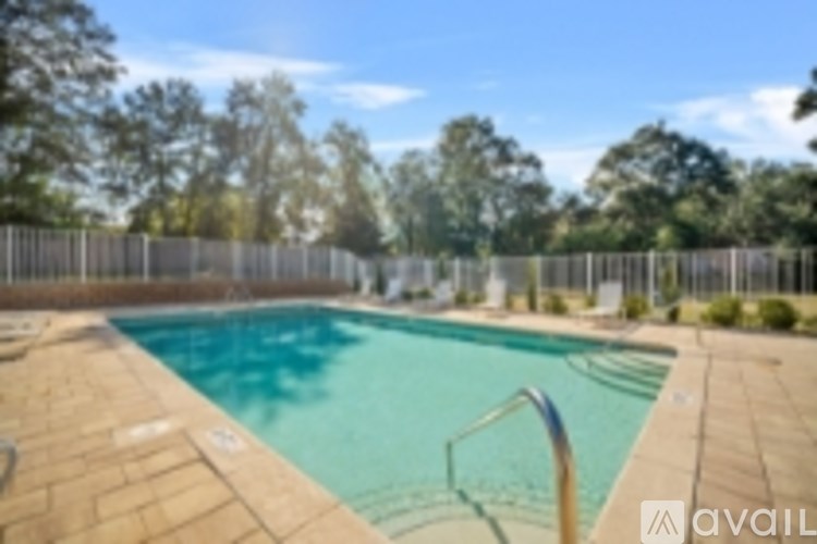 A pool surrounded by a fence and trees.