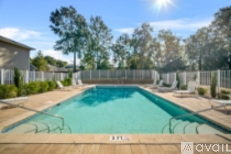 A pool surrounded by a wooden deck and a fence.