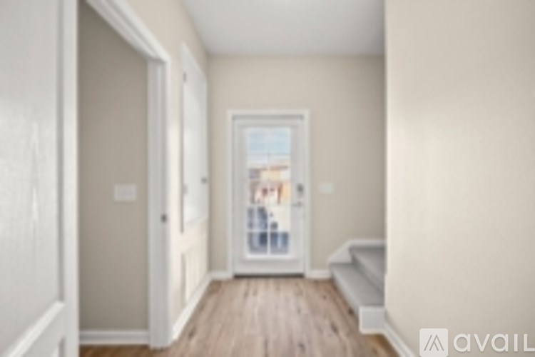 A hallway with a door leading to a balcony.