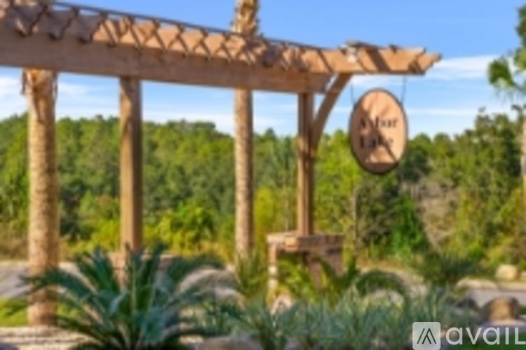 A wooden pergola with a sign that reads "Aloha" is surrounded by greenery.