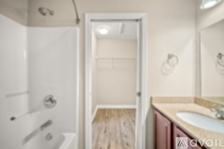 A bathroom with a sink, mirror, and shower.