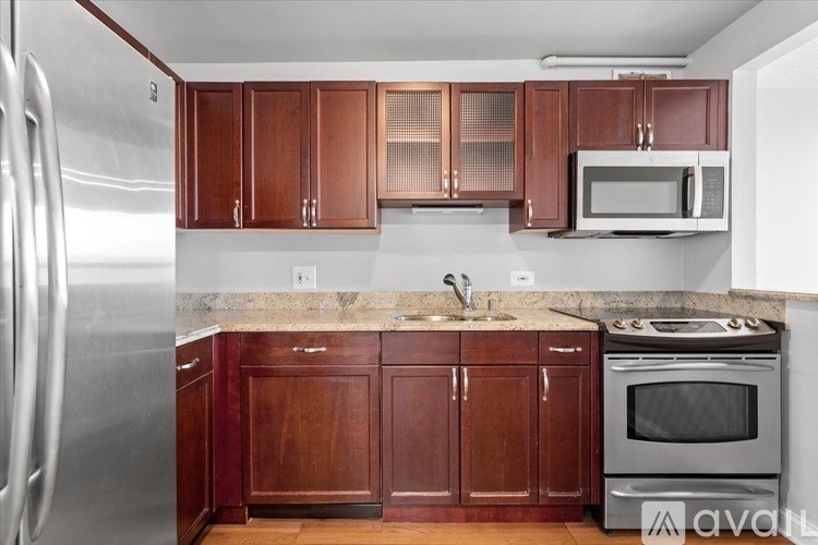 A kitchen with wooden cabinets and a stainless steel refrigerator.