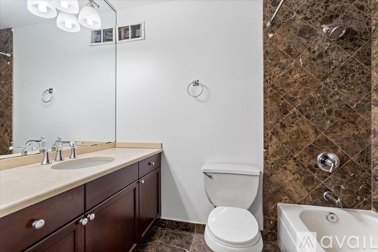 A bathroom with a sink, toilet, and a shower.