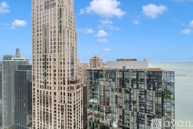A tall building stands in front of a body of water.