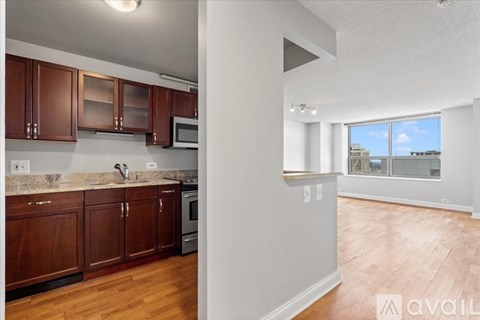 A kitchen with wooden cabinets and a microwave.