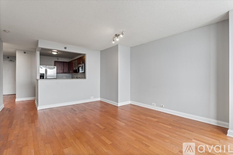 A spacious room with wooden flooring and white walls.