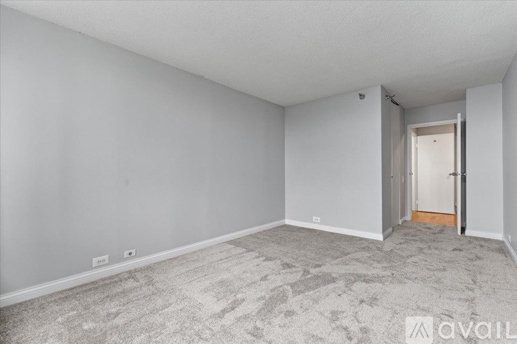 A room with a carpeted floor and a doorway leading to another room.