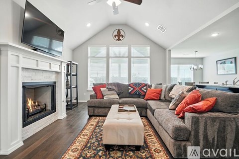 A living room with a grey couch and a fireplace.