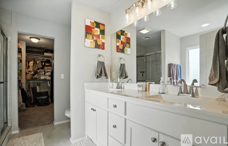 A bathroom with a white vanity and a mirror above it.