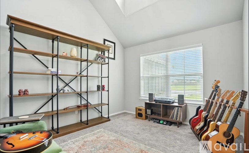 A room with a guitar wall and a guitar on the floor.