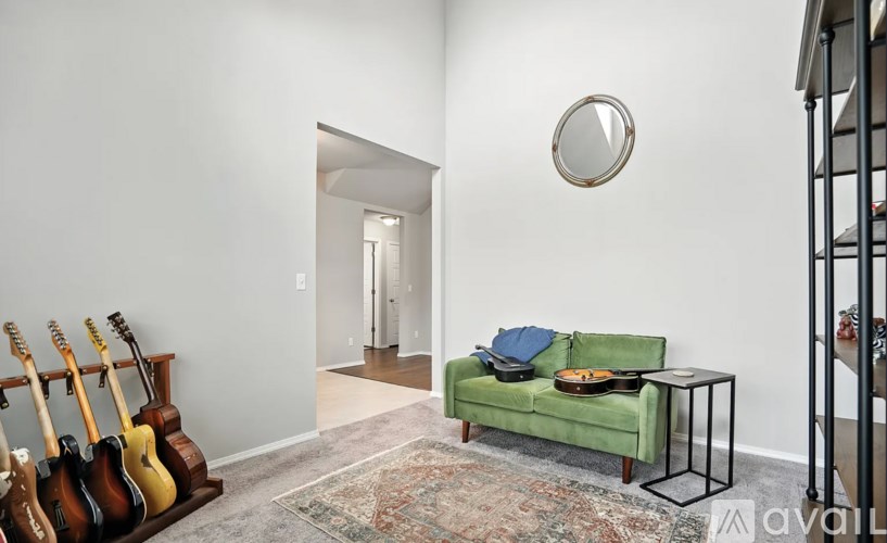 A living room with a green couch and guitars on a stand.