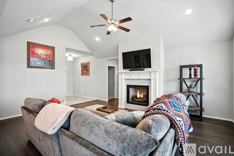 A living room with a grey couch and a fireplace.