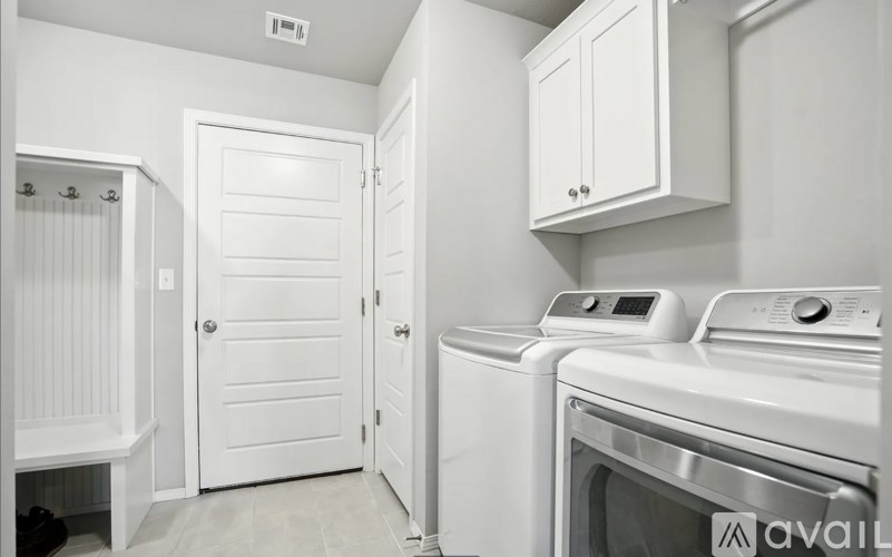 A white laundry room with a washer and dryer.