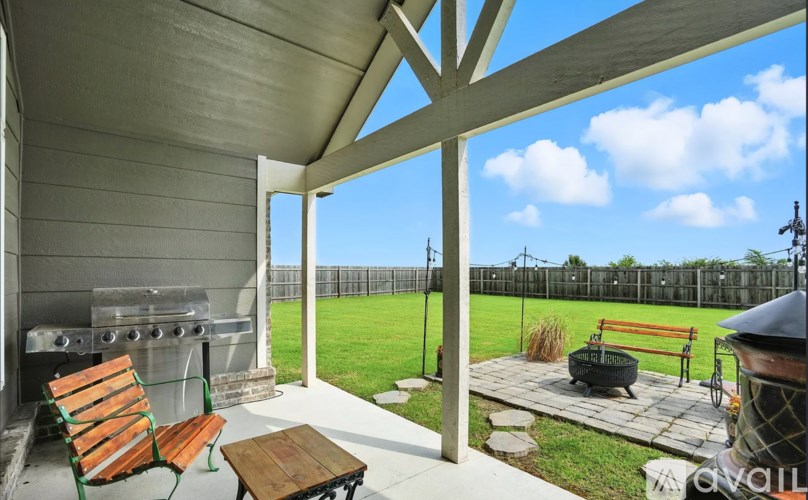 A patio with a table and chairs overlooking a fence.