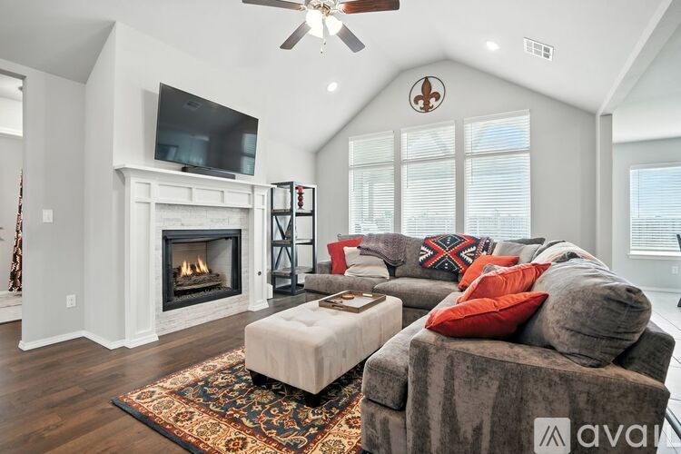 A living room with a grey couch and a fireplace.