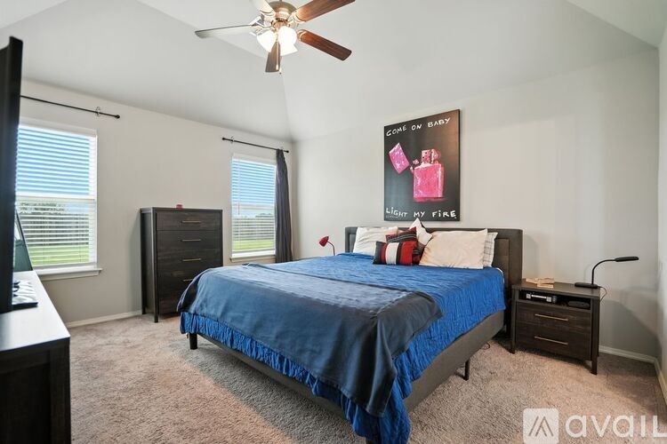 A bedroom with a bed, dresser, and ceiling fan.