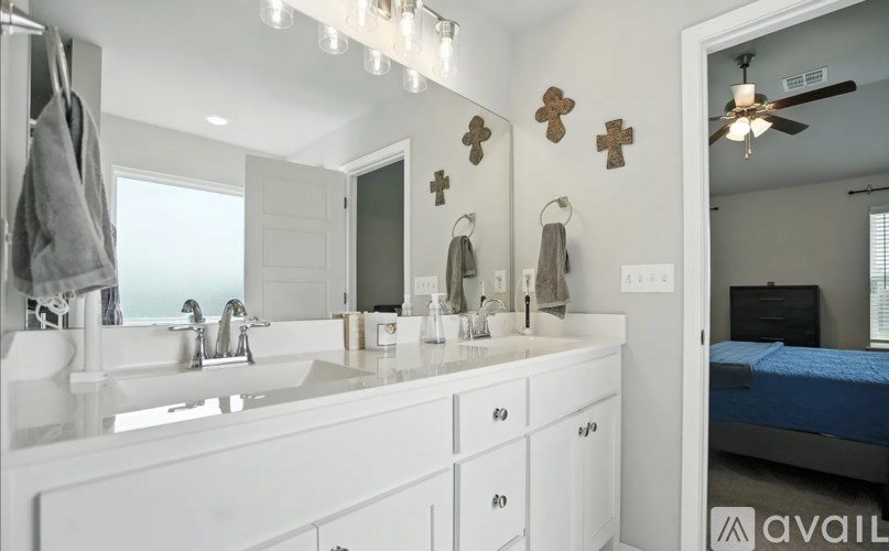 A bathroom with a double sink vanity and a mirror above it.