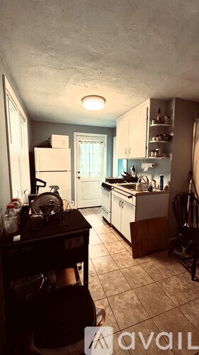 A kitchen with white cabinets and a wooden floor.