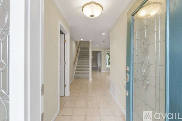 A hallway with a staircase and a blue door.