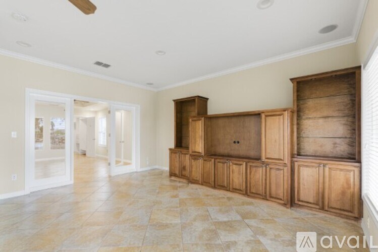 A spacious room with wooden cabinets and tiled flooring.