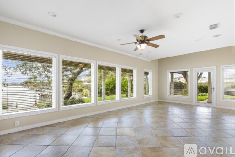 A spacious room with a ceiling fan and large windows.