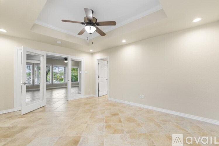 A spacious room with a ceiling fan and lighting fixtures.