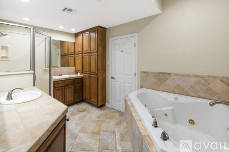 A bathroom with a tub, sink, and mirror.