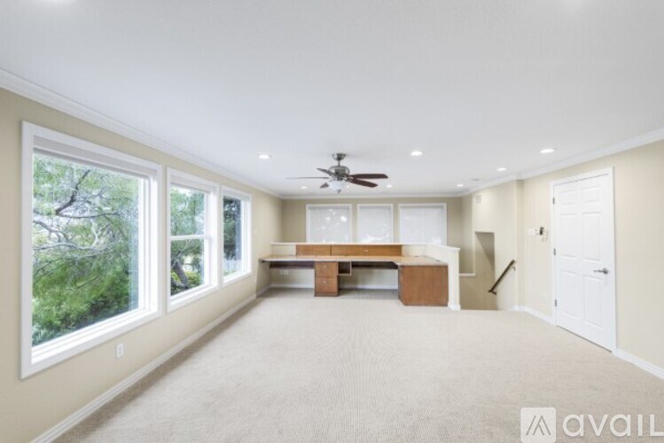 A spacious room with a table and chairs and a ceiling fan.