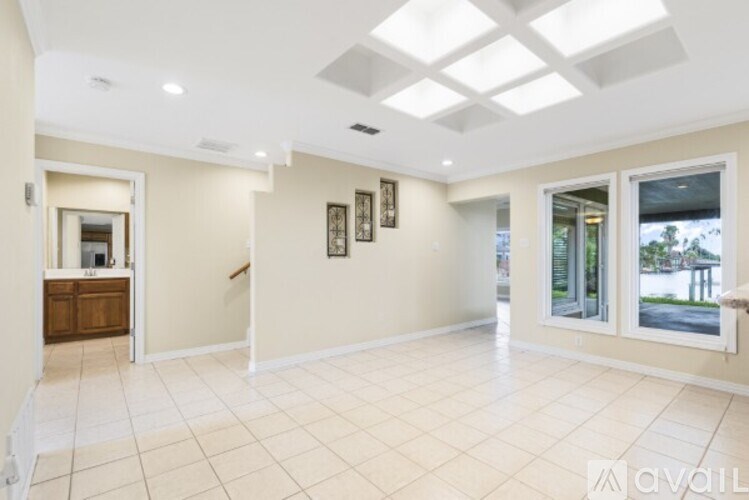 A spacious room with a skylight and a view of the outdoors through a sliding glass door.