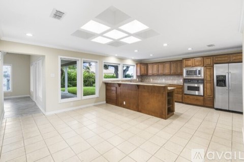 A spacious kitchen with wooden cabinets and stainless steel appliances.