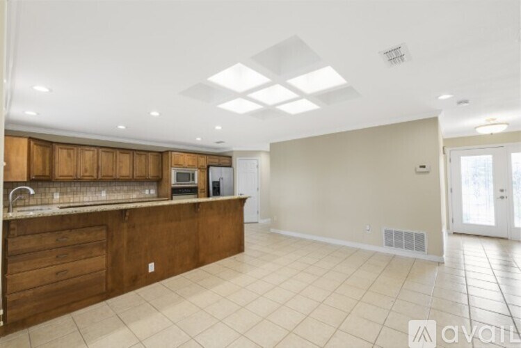 A kitchen with wooden cabinets and a tiled floor.
