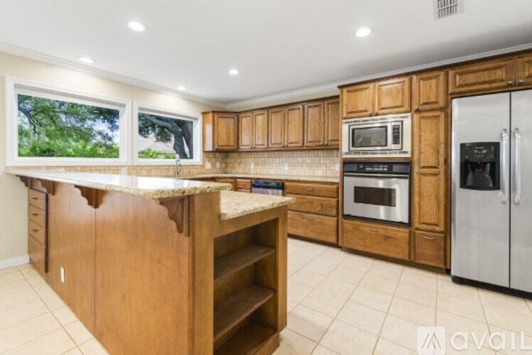 A kitchen with wooden cabinets and a granite countertop.
