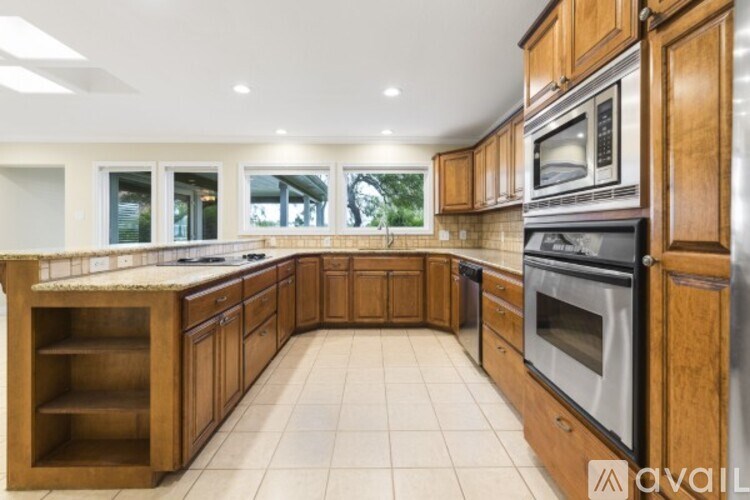 A kitchen with wooden cabinets and a tile floor.