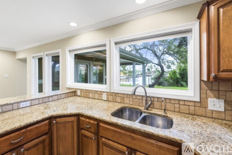 A kitchen with granite countertops and wooden cabinets.