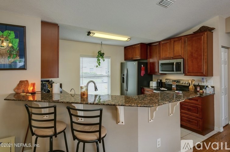 A kitchen with granite countertops and wooden cabinets.