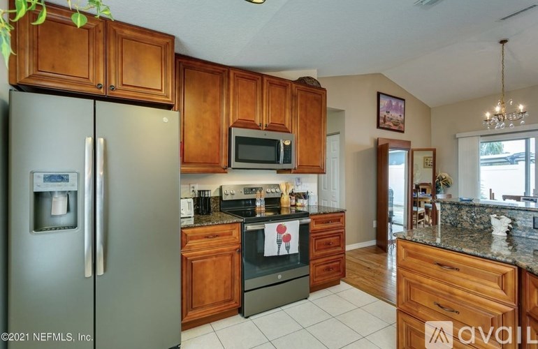 A kitchen with wooden cabinets and a granite countertop.