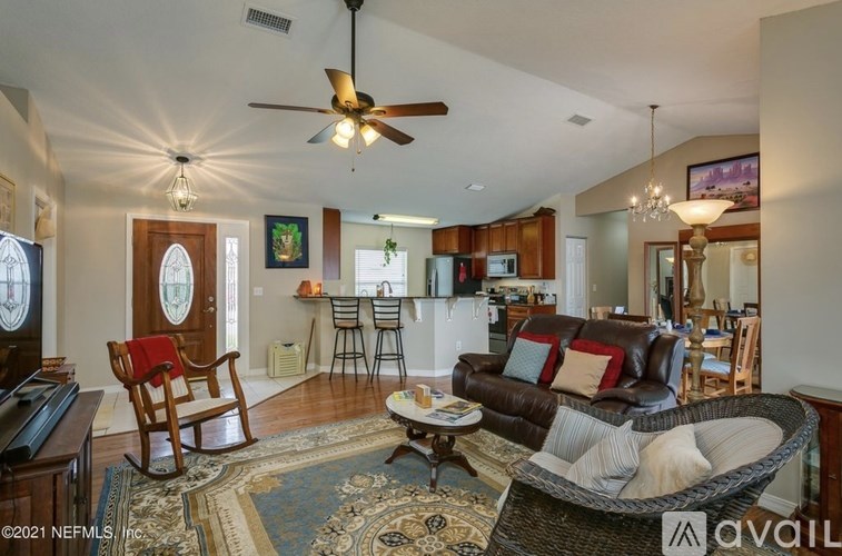 A living room with a brown leather couch and a rug.