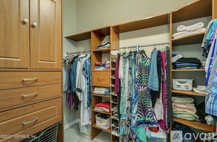 A closet with clothes hanging and folded on shelves.