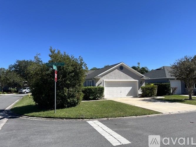 A street view of a residential area with houses and a street sign.
