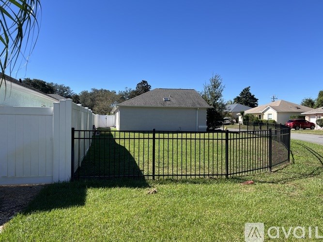 A black metal fence in front of a white house.
