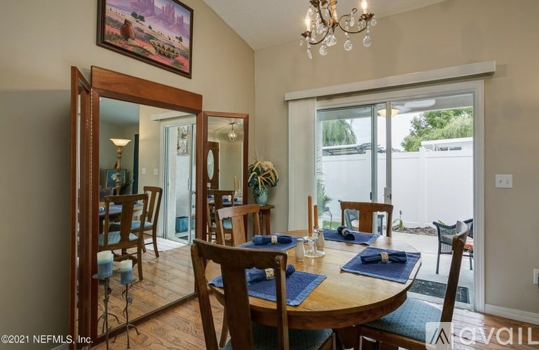 A dining room with a wooden table set for a meal.