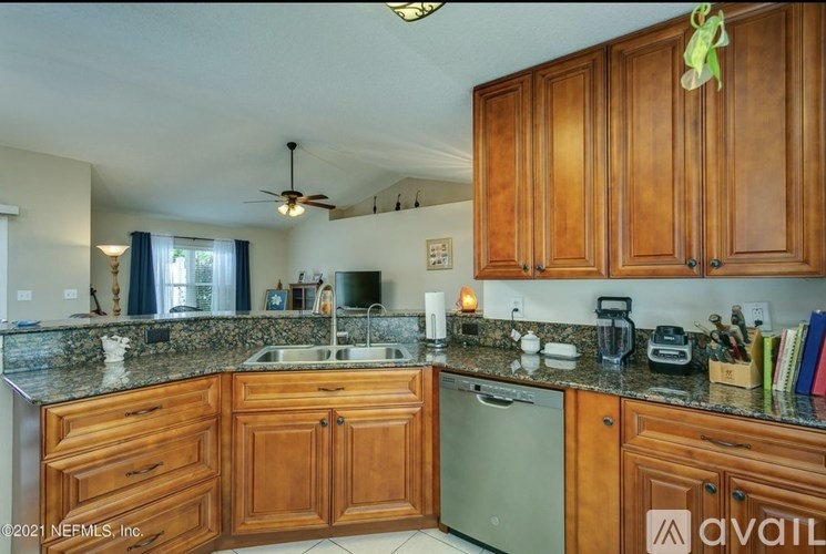 A kitchen with wooden cabinets and a granite countertop.