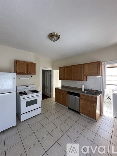 A kitchen with white appliances and wooden cabinets.