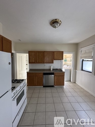 A kitchen with white appliances and wooden cabinets.
