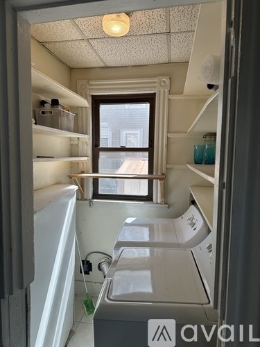 A small, white-walled bathroom with a window and a sink.