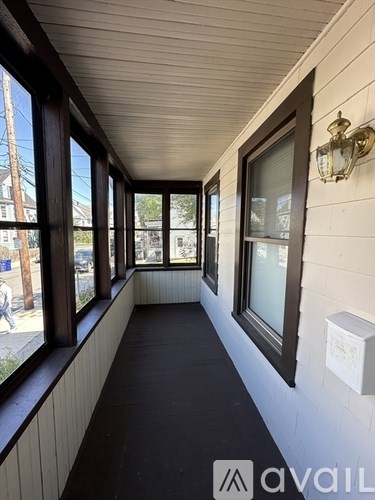 A long hallway with windows on the side and a light on the wall.