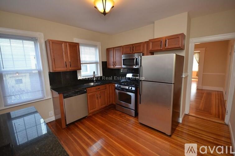 A kitchen with a stainless steel refrigerator, microwave, and oven.