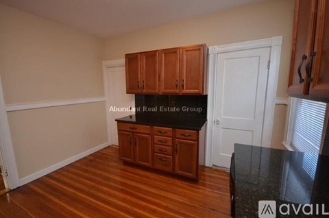 A kitchen with wooden cabinets and a black countertop.