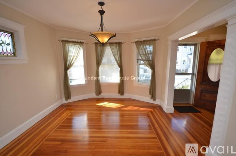 A room with wooden floors and a chandelier hanging from the ceiling.