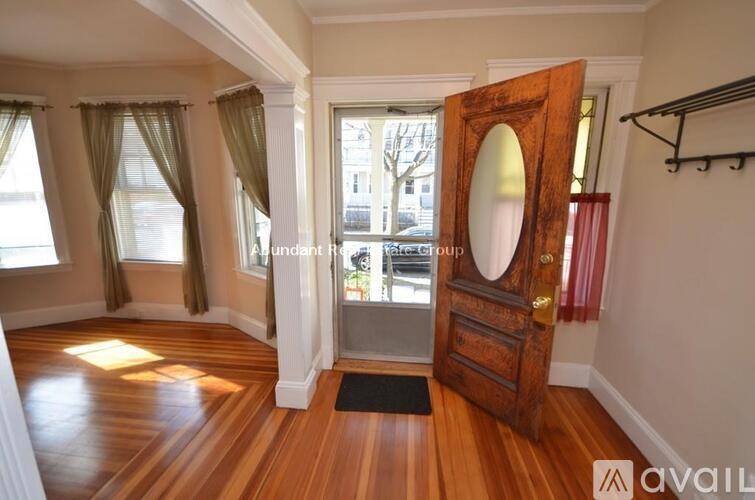 A room with a wooden floor and a mirror on the door.